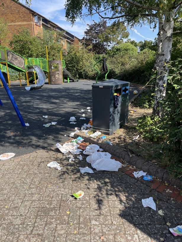 Overflowing bins and litter around the play area.